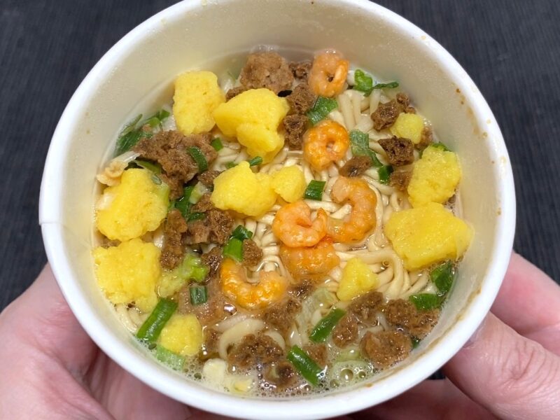 コスモスON365・旨口しょうゆヌードルの完成品・エビ・卵・そぼろなど5種の具材が並ぶ