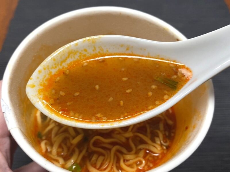 コスモスON365・担担麺のスープをレンゲですくった様子・練りごま入りの赤いスープ