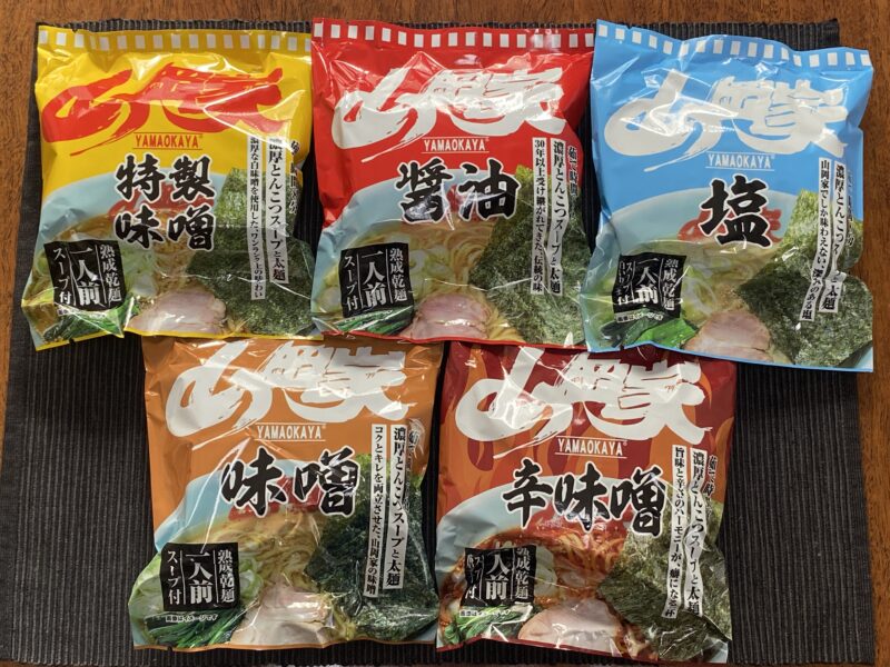 山岡家乾麺5種（特製味噌・醤油・塩・味噌・辛味噌）のパッケージを扇状に並べた食べ比べセット