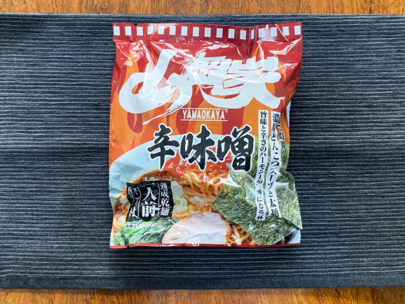 山岡家乾麺・辛味噌のパッケージ正面（赤・オレンジの炎デザイン