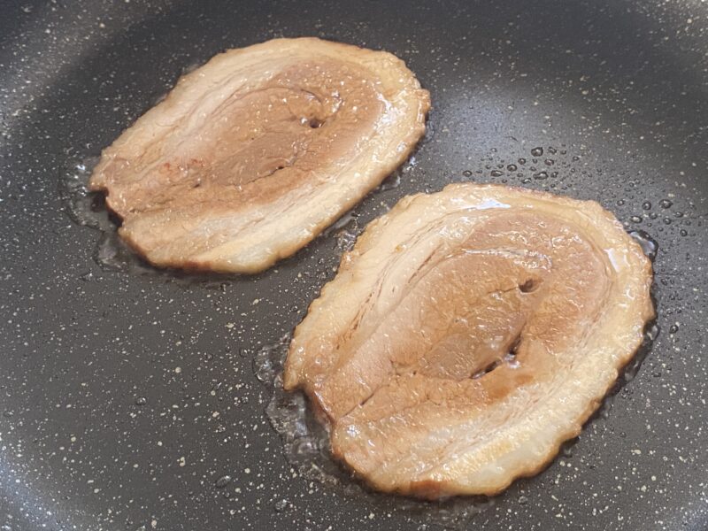 フライパンで焼いている大判厚切りバラ焼豚