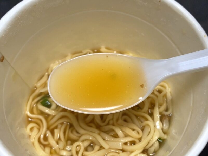 コスモスON365・旨口しょうゆヌードルのスープをレンゲですくった様子・あっさり色の澄んだ醤油スープ