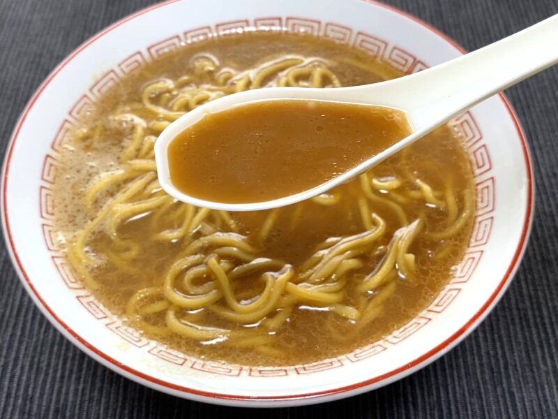 山岡家乾麺・醤油のスープをレンゲですくった様子・濃厚な茶色いスープ