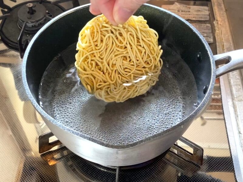 山岡家乾麺を沸騰したお湯に投入する調理工程