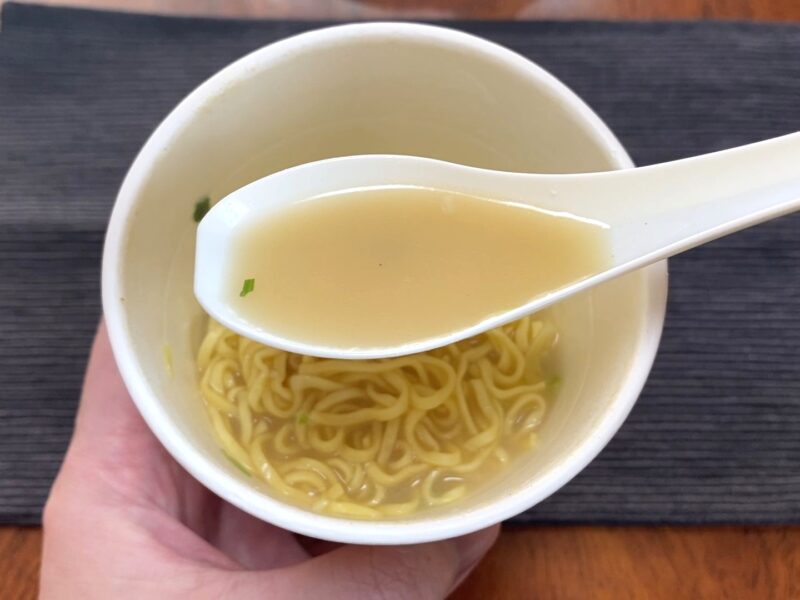 コスモスON365・シーフードヌードルのスープをレンゲですくった様子・あっさりした白濁スープ