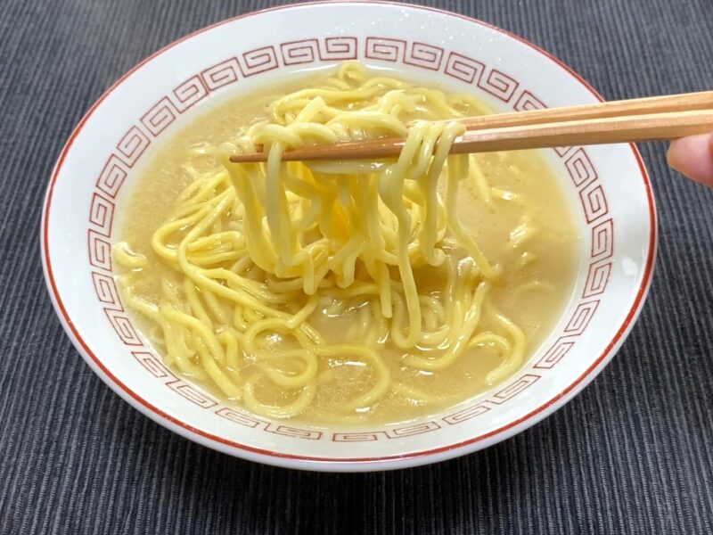 山岡家乾麺・塩の太麺を箸で持ち上げた様子・白いスープが絡んだ状態