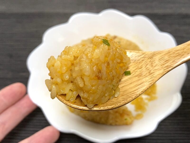木製スプーンで天下一品監修炒飯をすくった別角度のアップ。しっとりまとまった独特の食感が分かる