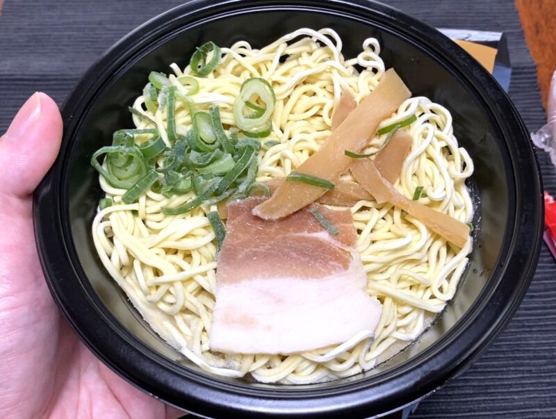 天下一品監修こってりラーメンの加熱前の状態。黒い器に麺・煮豚・メンマ・ねぎが凍った状態で入っている