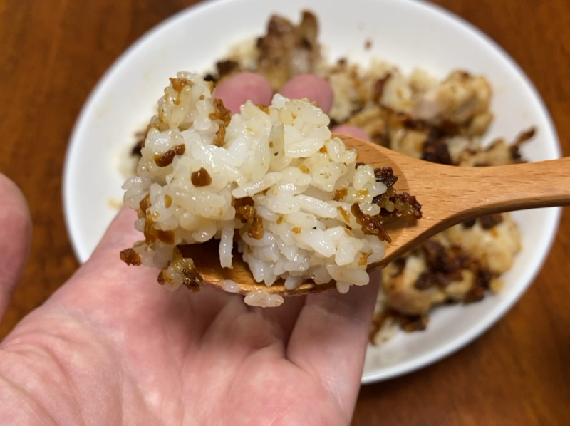 木のスプーンですくった混ぜご飯のアップ。ご飯粒にフライドオニオンが絡んでいる